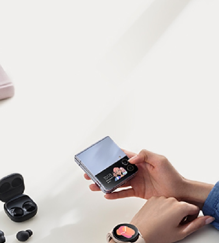 Vyras, laikantis „Galaxy Z Flip4“, segintis „Galaxy Watch“ ir naudojantis „Galaxy Buds“