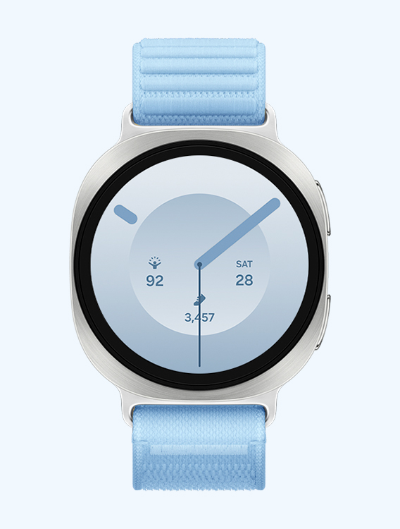 Front view and close-up angled view of Galaxy Watch9 with a Fabric Band in Blue, displaying a watch face with information such as time, Energy Score, date and number of steps.