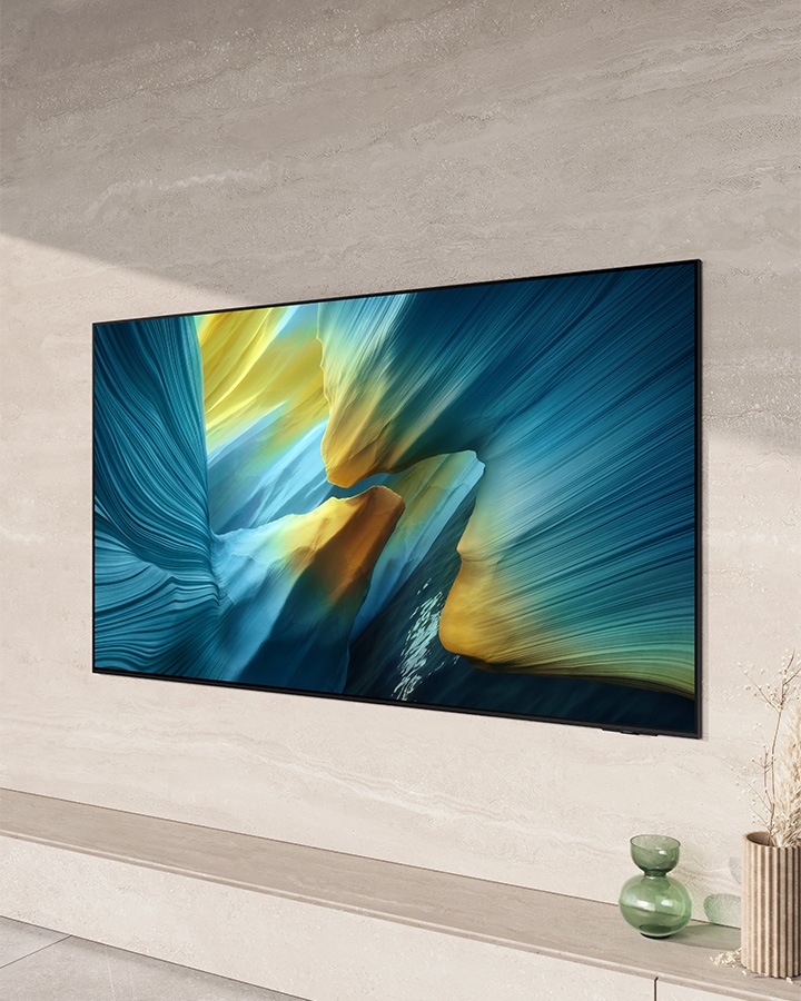 Een grote Samsung OLED TV hangt tegen de muur in een lichte, moderne woonkamer.