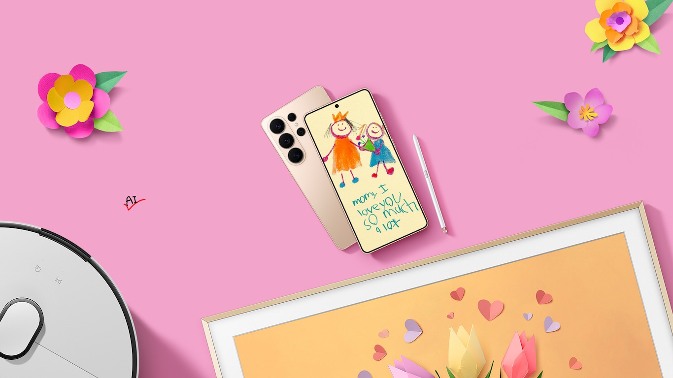 A close-up of a Galaxy S26 Ultra displays a child’s drawing with the handwritten message, 'Mom, I love you so much a lot'. The Galaxy S26 Ultra zooms out, revealing The Frame Pro displaying paper-made flowers and hearts. The Frame Pro then slides to one side, partially revealing the Bespoke AI Jet Bot Steam Ultra in Satin Grey. Two Galaxy S26 Ultra devices and an S Pen are shown. A handwritten AI checkmark graphic is added to the text to read ‘Your AI companion to family rituals’.