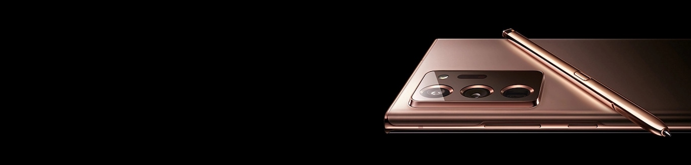 The upper half of Galaxy Note20 Ultra in Mystic Bronze, seen laying facedown in landscape mode. The matching S Pen is laying across its back.