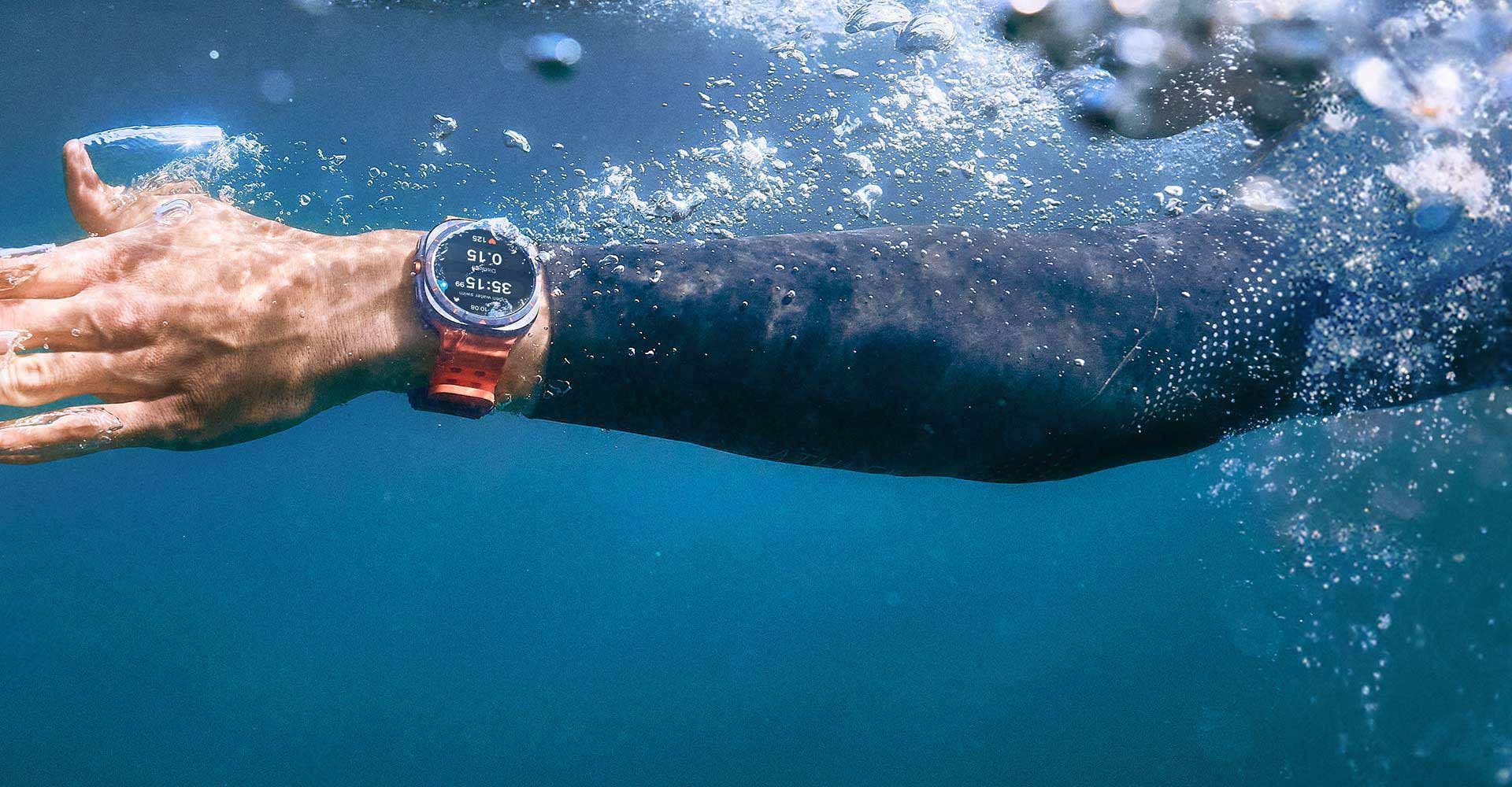 A hand in the water wearing a Galaxy Watch Ultra on the wrist.