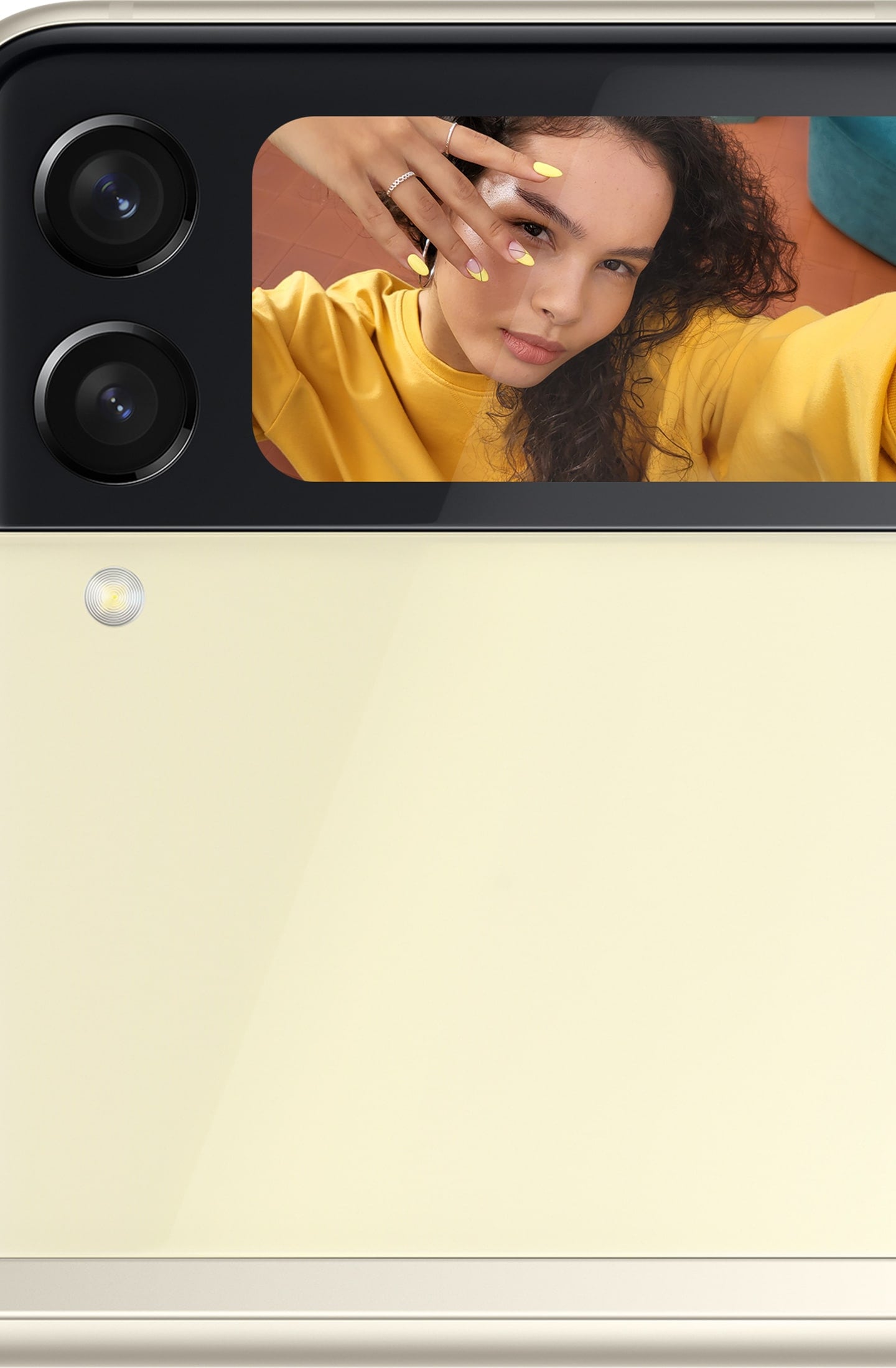 The Front Cover of Galaxy Z Flip3 5G with a woman taking a selfie shown in the Cover Screen.