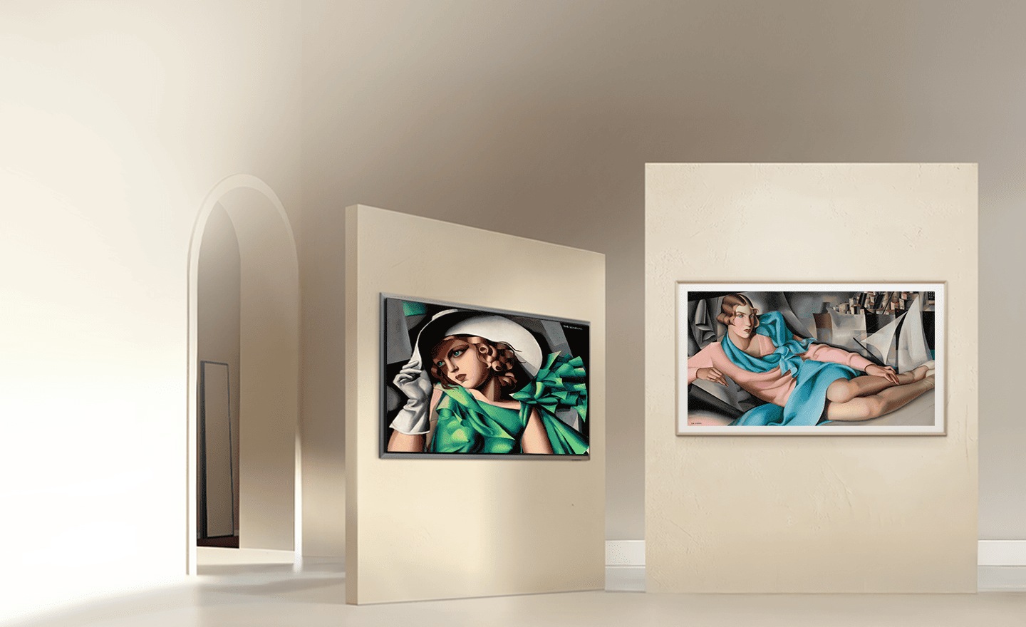 Obrazy w TV wiszą na beżowych ścianach w jasnym, surowym, minimalistycznym wnętrzu. Na ekranach Samsung TV z serii The Frame i Micro RGB wyświetlane są dwa obrazy Tamary Łempickiej. Po lewej stronie widoczne jest dzieło „Dziewczyna w zielonej sukience”, a po prawej „Rafaela na tle miasta”.