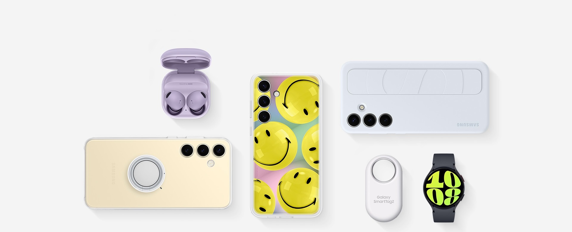 Akcesoria do Galaxy S24 Plus leżące płasko: fioletowy Galaxy Buds2 Pro z otwartym opakowaniem ze słuchawkami w środku, Galaxy S24 Plus w etui Clear Gadget Case, Galaxy S24 Plus z żółtym Flipsuit Case, Galaxy S24 Plus z jasnoniebieskim Standing Grip Case, biały Galaxy SmartTag2 i grafitowy Galaxy Watch6.