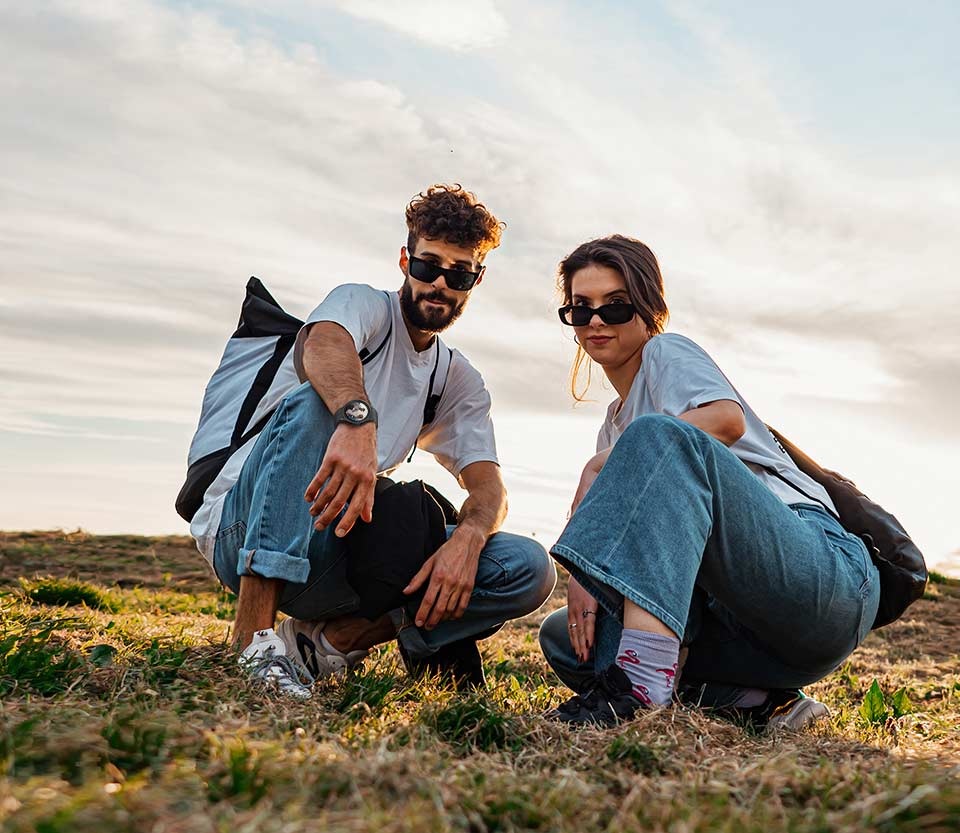 صورة لشخصين يتخذان وضعية لالتقاط صورة بزاوية منخفضة من مسافة بعيدة باستخدام الساعة Galaxy Watch5 Pro للتحكم في كاميرا الهاتف الذكي.