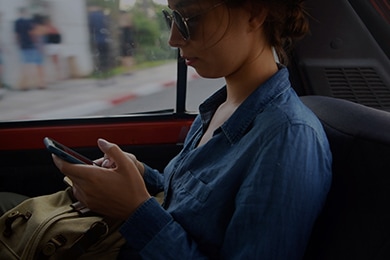 Mujer en un automóvil utilizando su teléfono de forma segura