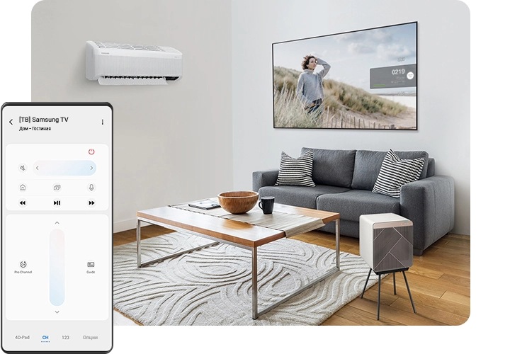 Гостиная с кондиционером на стене и очистителем воздуха Cube Air Purifier, который стоит рядом с журнальным столиком в центре комнаты. За столиком находится диван, а над диваном 65-дюймовый QLED-телевизор Q7, закрепленный на стене. Слева на переднем плане на экране Galaxy показан пульт ДУ Smart TV.