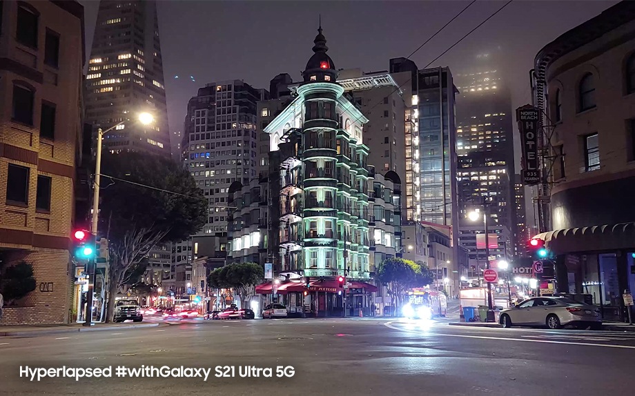 An urban nighttime scene of lit-up buildings at a traffic intersection in San Francisco. Hyperlapsed #withGalaxy S21 Ultra 5G