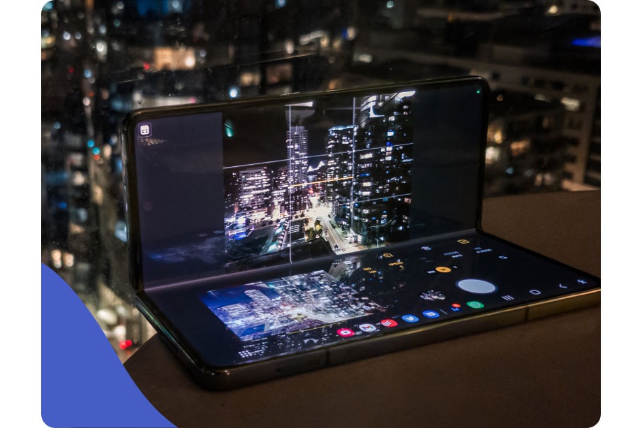 Складной смартфон Galaxy Z Fold4 в полураскрытом положении, фотосъёмка ночного города на телефон, статичный кадр без штатива