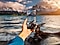  Неподалеку от океана мужчина фотографирует море на свой мобильный телефон.