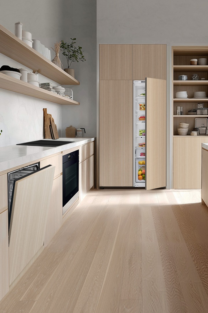 A light kitchen with wooden panels with an open dishwasher and a refrigerator door