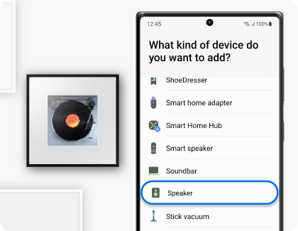 Un teléfono Samsung Galaxy mostrando la aplicación SmartThings (y la opción Altavoz resaltada), junto a un Samsung Music Frame