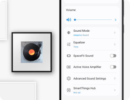 A Samsung Galaxy phone displaying the SmartThings app is positioned next to a Samsung Music Frame