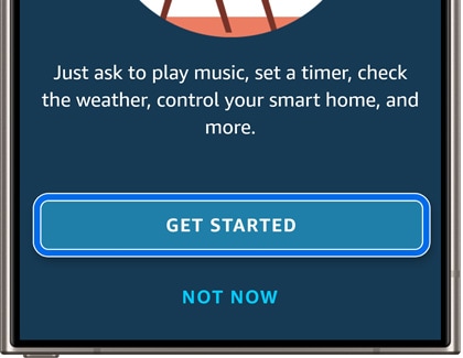 A Galaxy phone screen displaying the Amazon Alexa app with options 'GET STARTED' and 'NOT NOW', inviting users to activate voice controls.