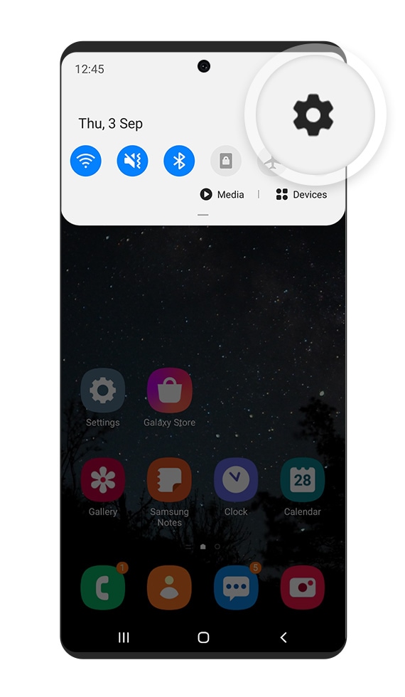 A smartphone with the Settings icon on the screen magnified.