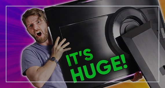 Linus looks into the camera holding an Odyssey Ark monitor in his hands with a look of surprise. The words behind the monitor read 'It's HUGE!'