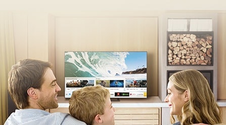 ผู้คน 3 คนในห้องนั่งเล่นกำลังดู Smart TV แอปต่าง ๆ ถูกแสดงอยู่บนทีวี เช่น DEEZER, คอนเสิร์ตฮอลล์ดิจิทัล, แกลเลอรี, Facebook Watch, Yupp TV, Redbull TV, tunein, Seecolors, NETFLIX, Prime Video, Apple TV, Google Play Movies & TV, YouTube, Spotify, SmartThings และอินเทอร์เน็ต. 