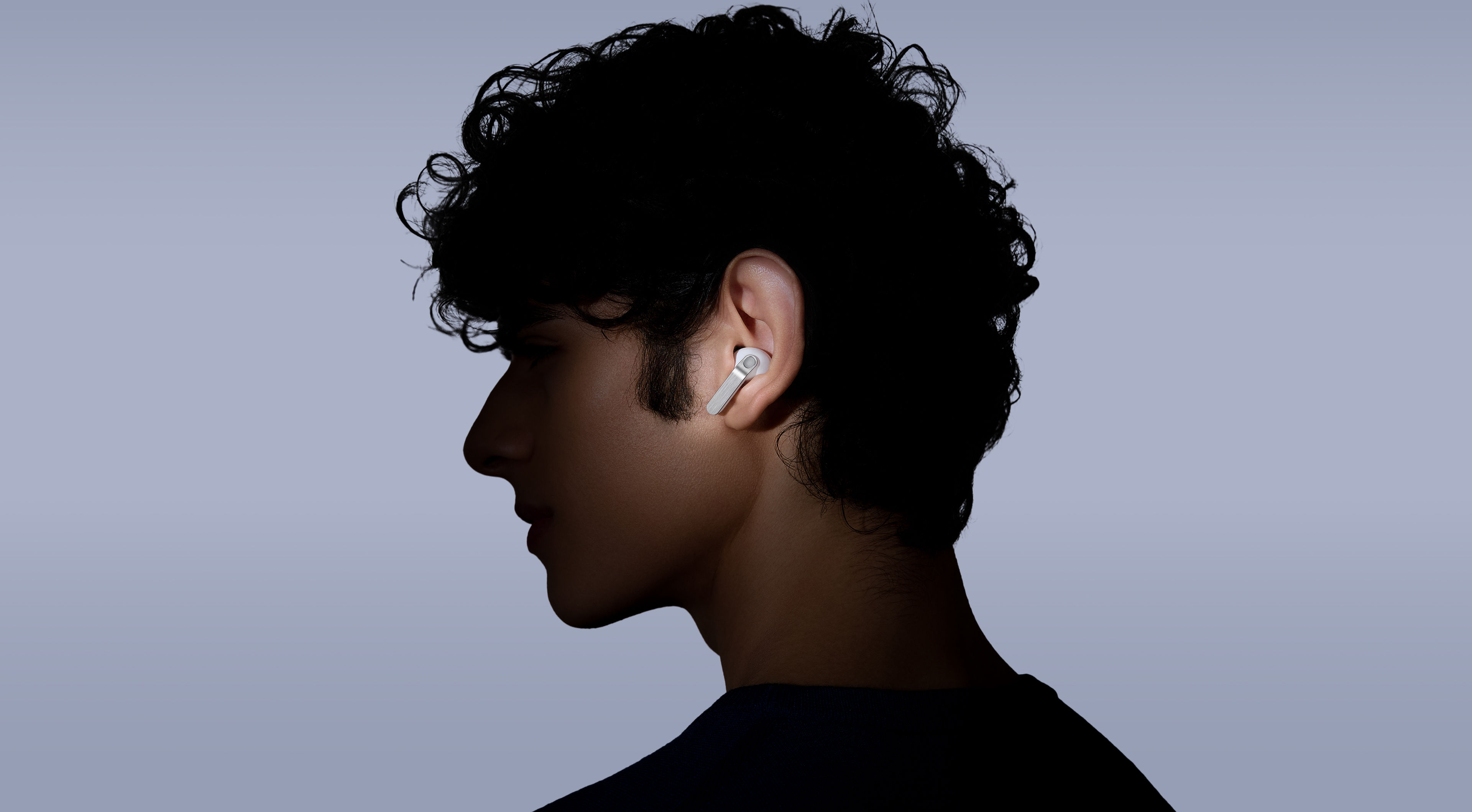 一位佩戴 Galaxy Buds4 Pro 的人看向左側。 The spotlight is on the real metal blade, which is a new design feature.