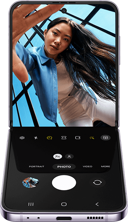 多角度拍攝模式下的 Galaxy Z Flip4。相機應用程式出現在內頁螢幕上，顯示了一張以低角度拍攝的女子照片。