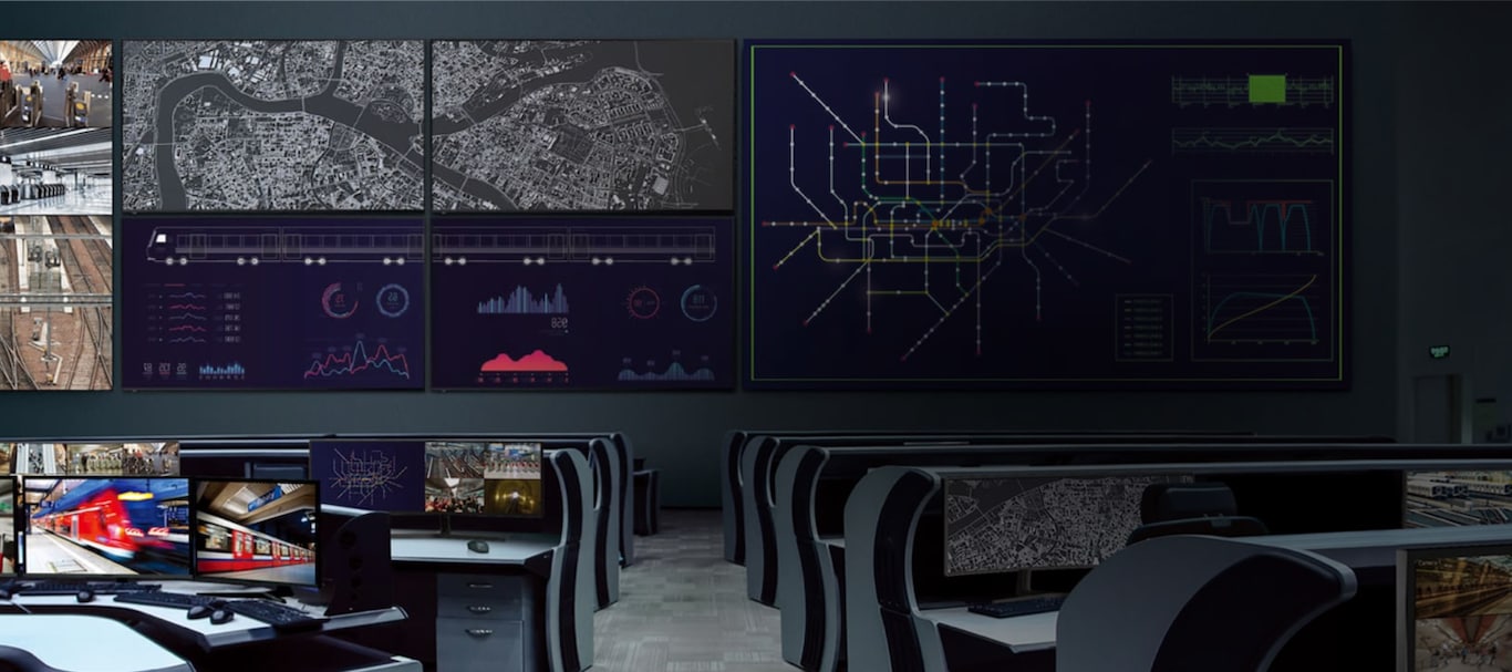 An image of the control room with multiple monitors and a wide screen view.