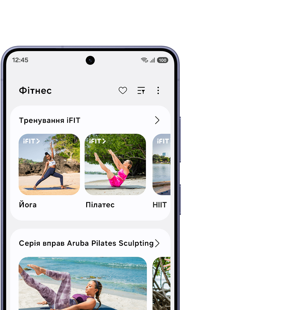 Galaxy Watch9 сріблястого кольору зі Спортивним ремінцем бежевого кольору лежить поруч із Galaxy S26. На екрані телефона відкрито застосунок iFIT, де відображаються різні тренування, створені тренерами, зокрема пілатес, HIIT та серія тренувань Sculpting. На дисплеї годинника відображається Тренування 1 із серії тренувань, розроблених тренерами, програми Тренер із бігу.