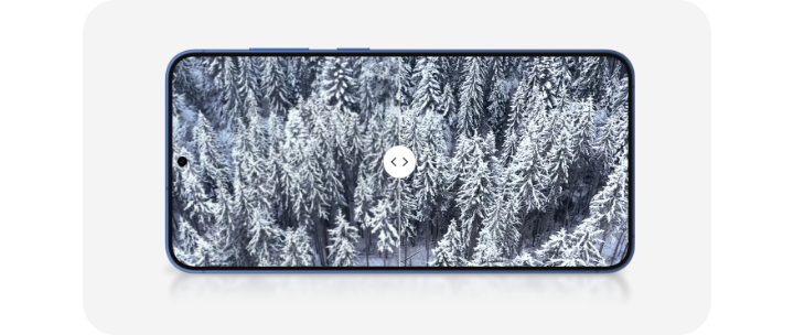 A snow covered forest is shown on the screen of a Galaxy S25 smartphone