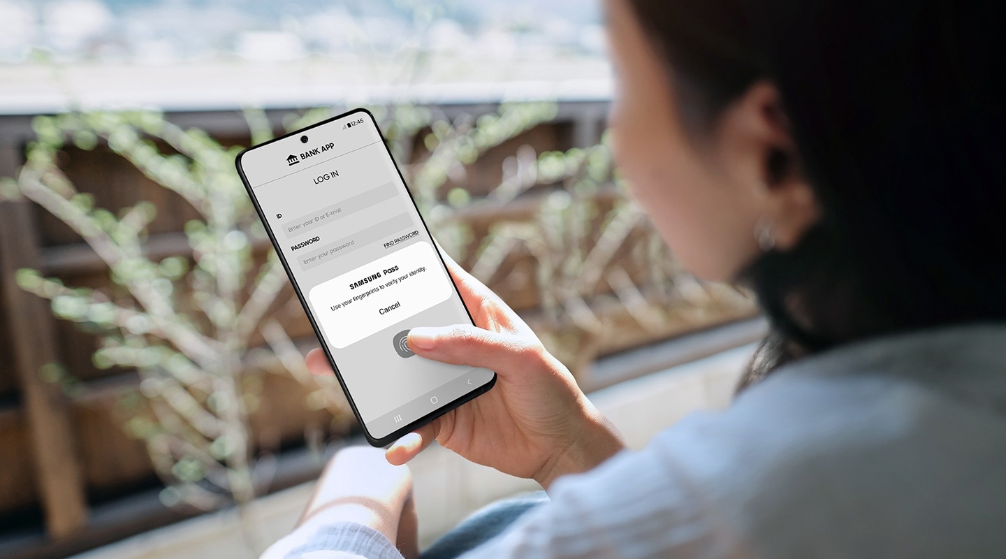 A Galaxy smartphone user uses her fingerprint to authenticate a Samsung Pass pop up message to log in to her bank app.