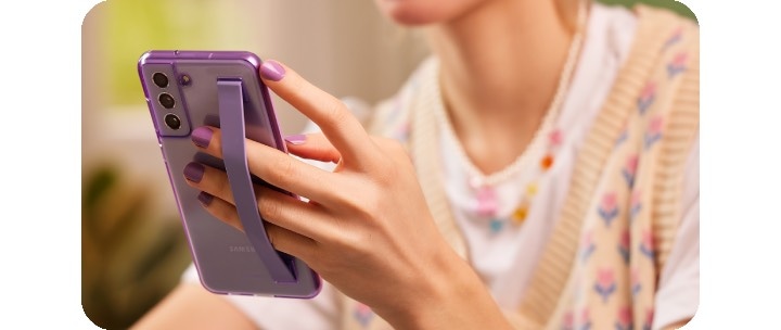 A woman holding Samsung Galaxy S21 FE 5G in one hand