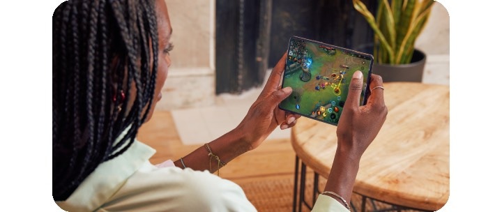 A woman playing mobile games on Samsung Galaxy S22 Ultra with two hands