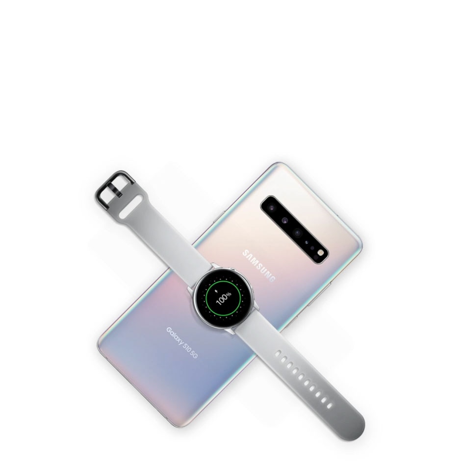 The Galaxy S10+ seen from the rear, laying flat at a 45 degree angle. As you scroll, another Galaxy S10+ appears on top of the first Galaxy S10+ and the charging icon appears, demonstrating Wireless PowerShare. As you continue scrolling, a Galaxy Watch Active appears and is charged on the Galaxy S10+ as well.