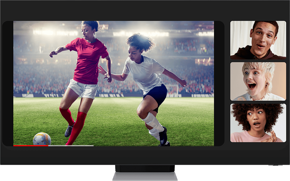 Two women playing football zooms out to become a video that three people are watching during a video call using Google Duo. The call is being cast onto a TV. Galaxy S22+ moves in front of the TV from off screen to show the same video call on the screen.