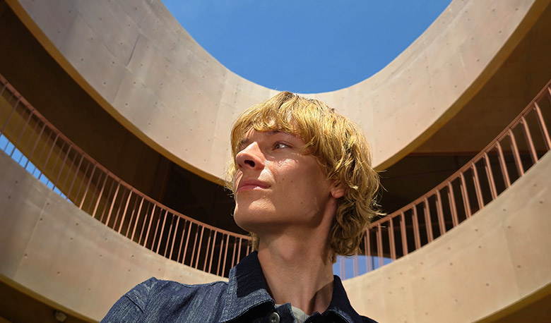 A 50 megapixel photo of a man against the backdrop of a building shows rich detail and color.