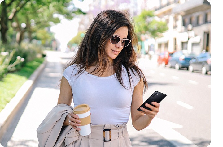 A woman using Bixby to turn on the air conditioner in advance while she is out.