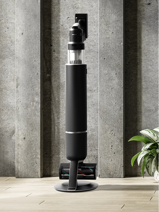 Matte Black Cordless Vacuum in a Custom Living Room with Cement Wall and Green Couch