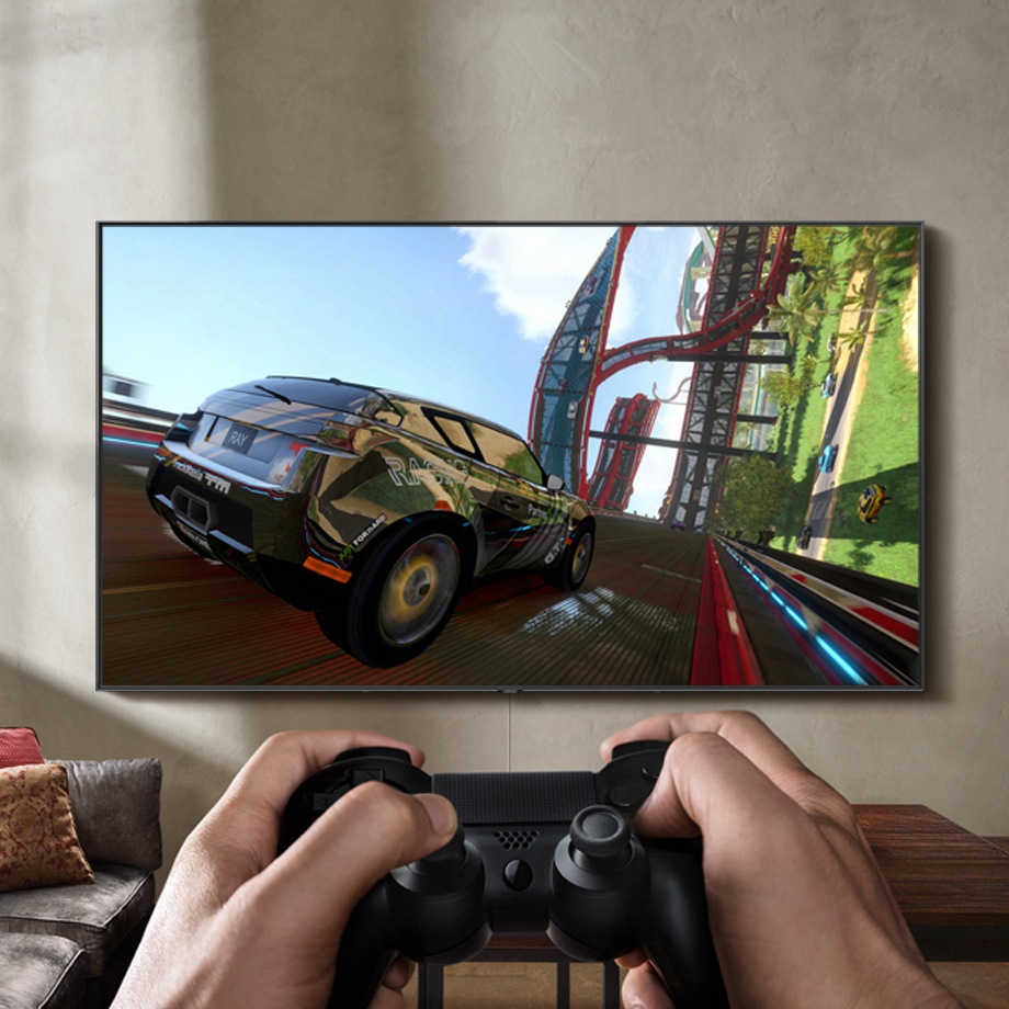 A video game controller shooting controller action symbols at a QLED TV mounted on the wall