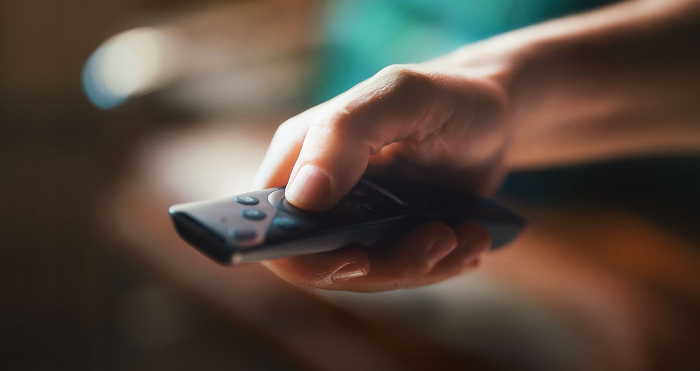 A hand holding the Samsung smart tv remote called One Remote and pointing it ahead