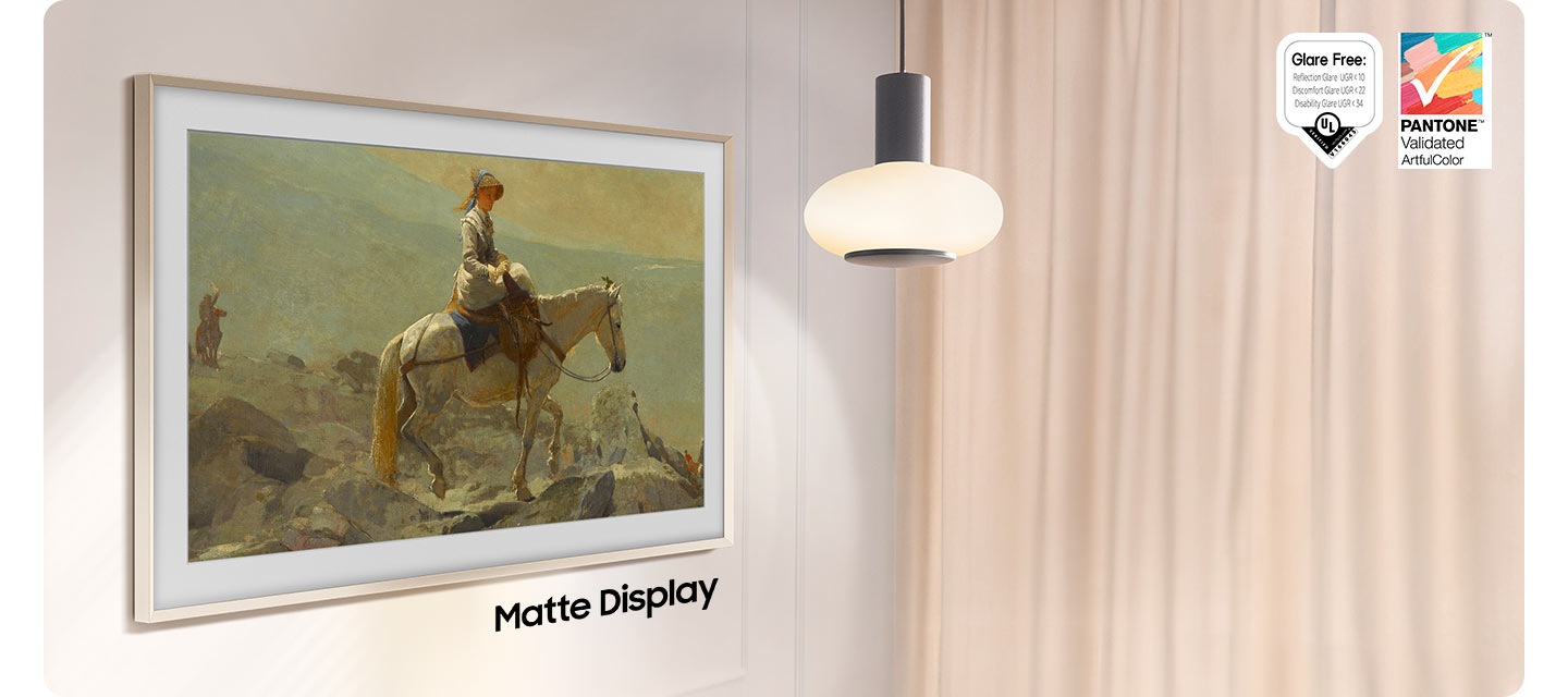 The Frame, which is turned off, reflects the light of a lamp hanging from the ceiling right next to it. The words Non Matte Display show below The Frame. Glare Free: Reflection Glare UGR<10, Discomfort Glare UGR<22, Disability Glare UGR<34, UL logo. PANTONE Validated ArtfulColor logo.