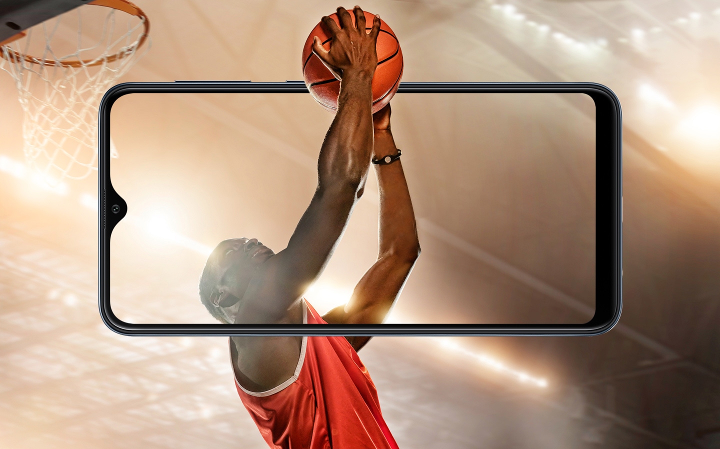 Jogador de basquete no ar em busca de uma enterrada. O movimento do jogador começa por fora de um celular Galaxy A10 e o braço do jogador passa por dentro do Display do smartphone.