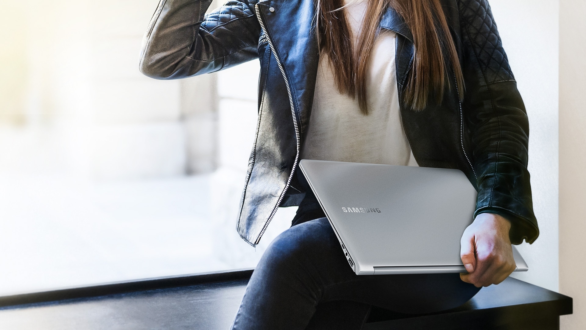 An image showing a female user carrying a Samsung Notebook 9.