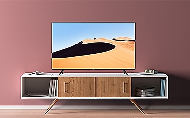 Un TV UHD 4K TU7070 in un salotto dalle pareti rosa