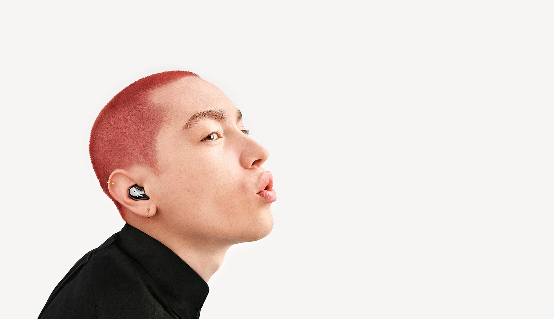 Un hombre con los Galaxy Buds Live en negro místico puestos está usando Bixby.