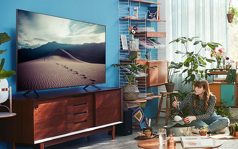 Una mujer está viendo la televisión.