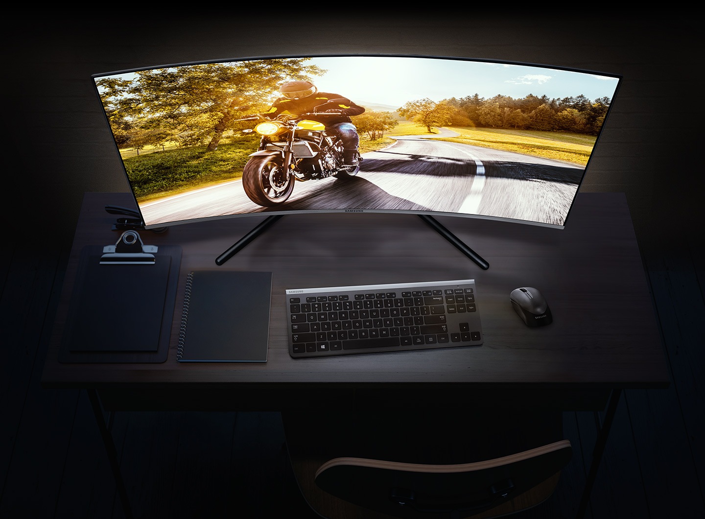 32 inch 4K monitor's 1500R screen is deeply curved for immersive viewing. 4K monitor on a desk with a man on motorbike on its curved screen