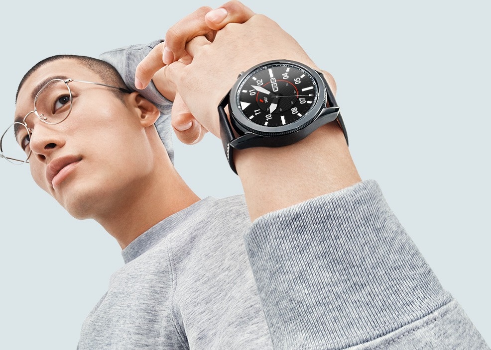 Man stretches his arms behind his back, showing off a 45mm Galaxy Watch3 in Mystic Black on his wrist with a Sporty Classic Watch Face.