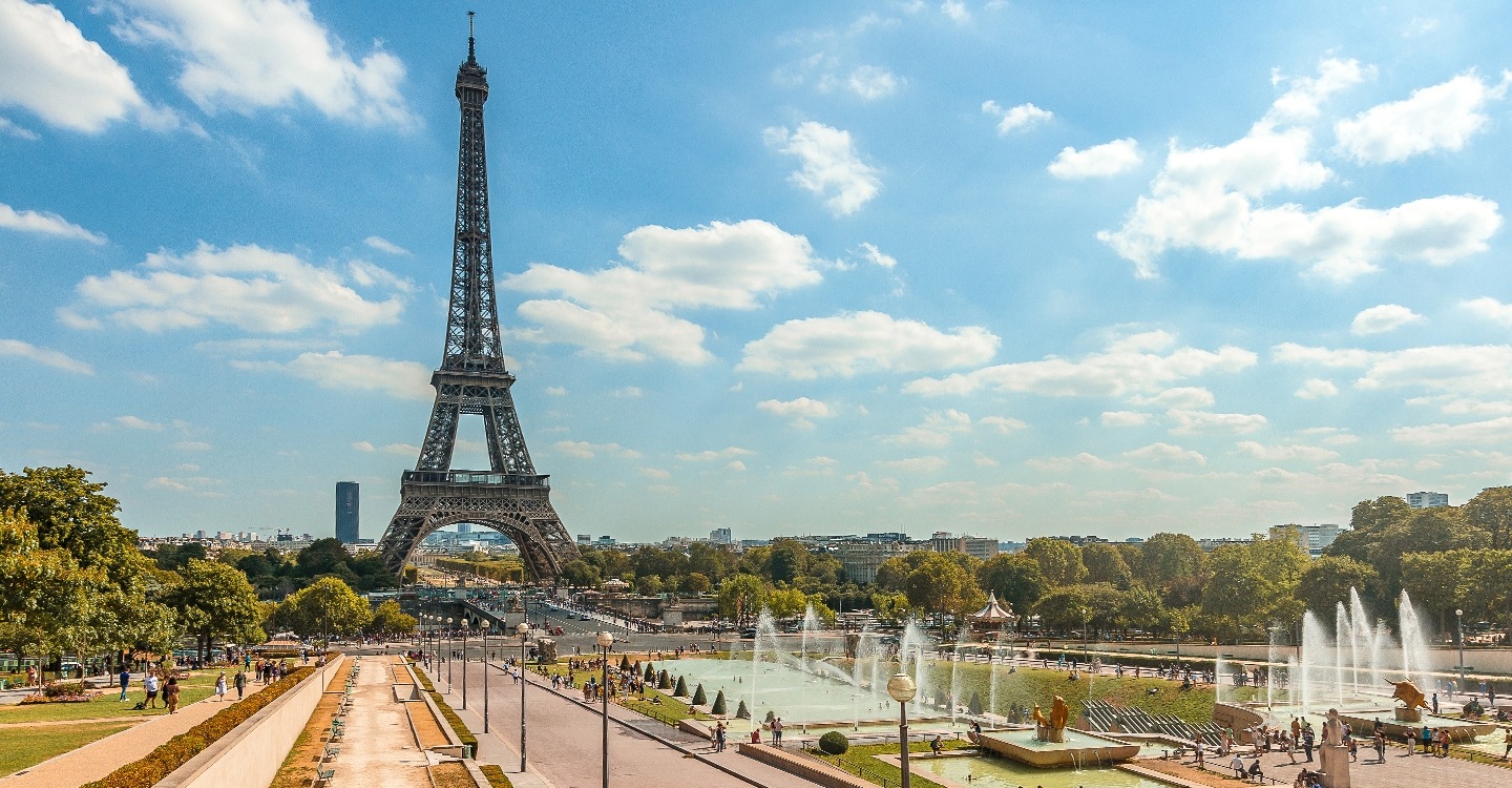 A breathtaking view of the Eiffel Tower and the Trocadéro Gardens on a sunny summer day.