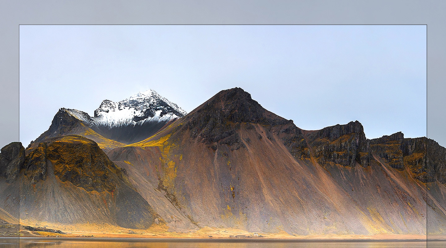 There is QLED TV in the middle of the mountain landscape. Samsung QLED is showing the mountain on the screen, blocking the real mountain. However, the minimal design of QLED with almost borderless tv bezel called infinity screen, it is showing a natural scene without a sense of incompatibility.