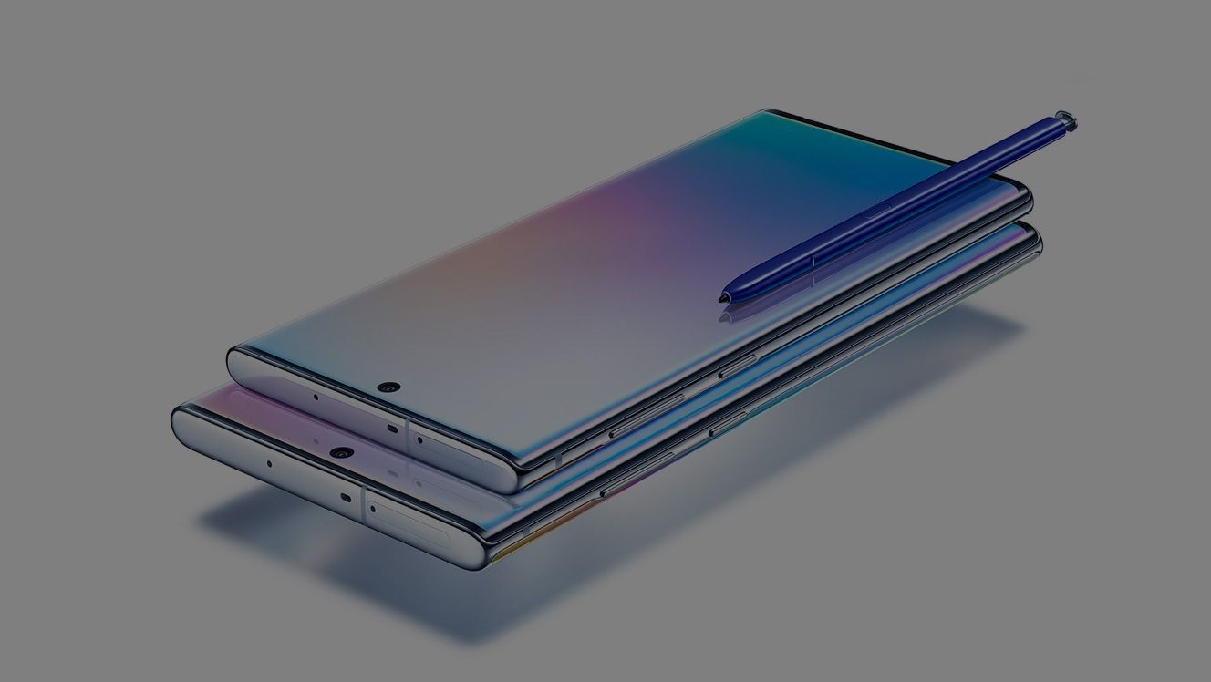 Galaxy Note10 laying on top of Galaxy Note10 plus, both laying on their back at an angle with a blue S Pen laying on top of Galaxy Note10. Each phone has a gradient graphic onscreen.