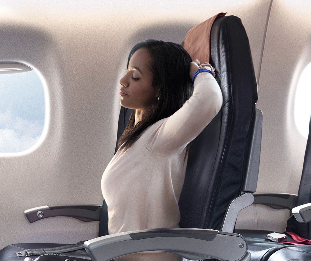 Image of woman stretching while sitting on plane