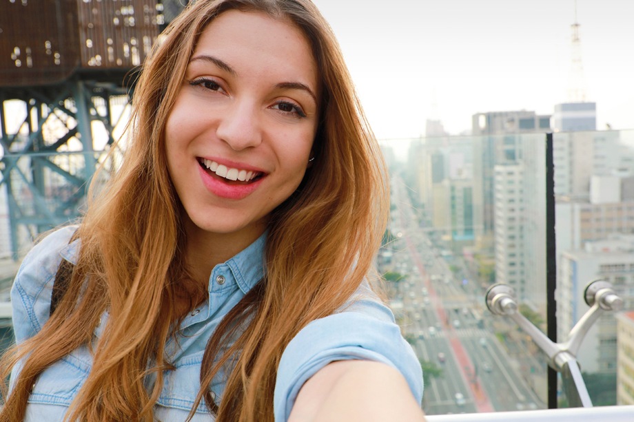 Imagem de uma mulher tirando selfies do alto de um edifício